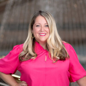 female with blond hair wearing pink shirt